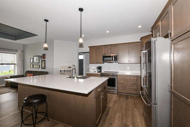 5150 Fairmont Dr, Milton, WI 53563 - kitchen featuring stainless steel appliances, a sink, dark wood-type flooring, light countertops, and a breakfast bar area
