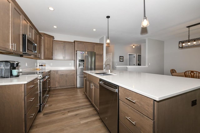 5150 Fairmont Dr, Milton, WI 53563 - kitchen featuring stainless steel appliances, a sink, wood finished floors, a spacious island, and light countertops