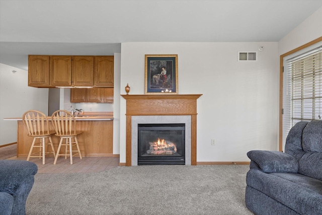 267 Oconomowoc Pkwy, Oconomowoc, WI 53066 - living area with baseboards, light colored carpet, a tile fireplace, and light tile patterned flooring