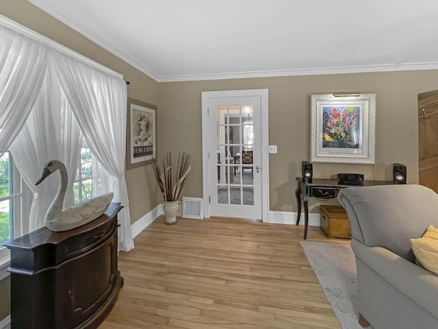 office space featuring crown molding, light wood-style flooring, and baseboards