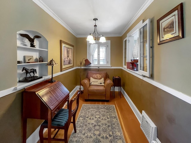 living area with a chandelier, crown molding, wood finished floors, and baseboards