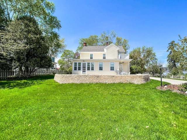 back of property with a balcony and a chimney
