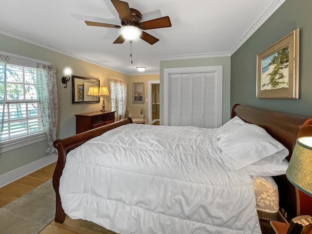 bedroom featuring multiple windows, wood finished floors, ornamental molding, a closet, and ceiling fan