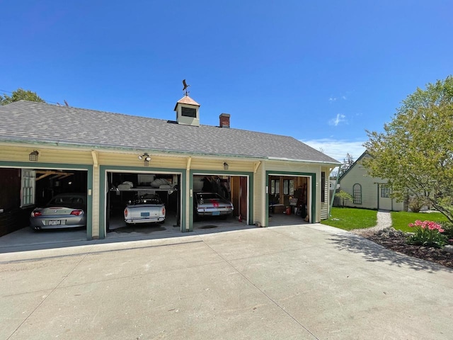 exterior space with a garage, a chimney, and driveway