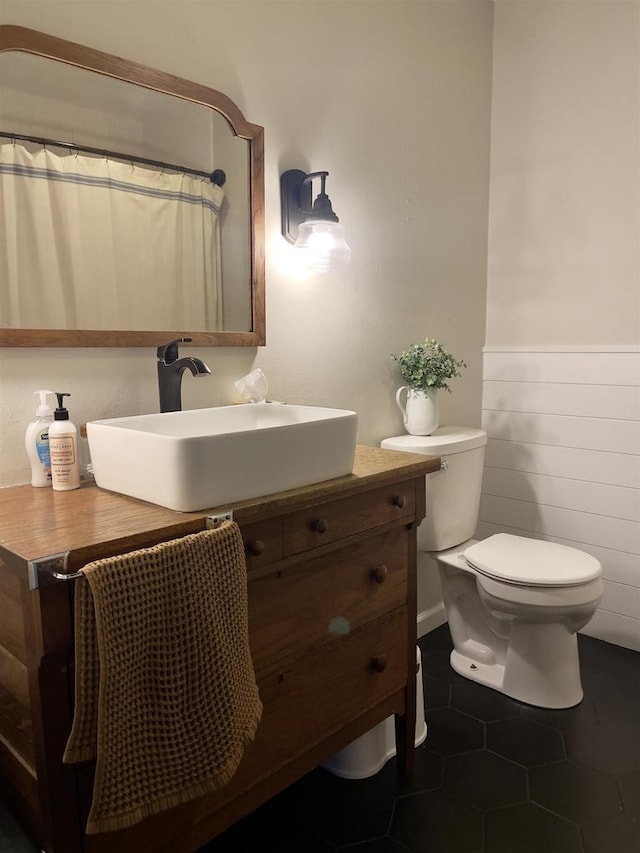 7401 Mildred Ct, Cross Plains, WI 53528 - bathroom with toilet, a wainscoted wall, tile patterned flooring, and vanity