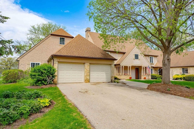 14 Golf Course Rd, Madison, WI 53704 - view of front of home featuring a garage, asphalt driveway, a chimney, and a shingled roof