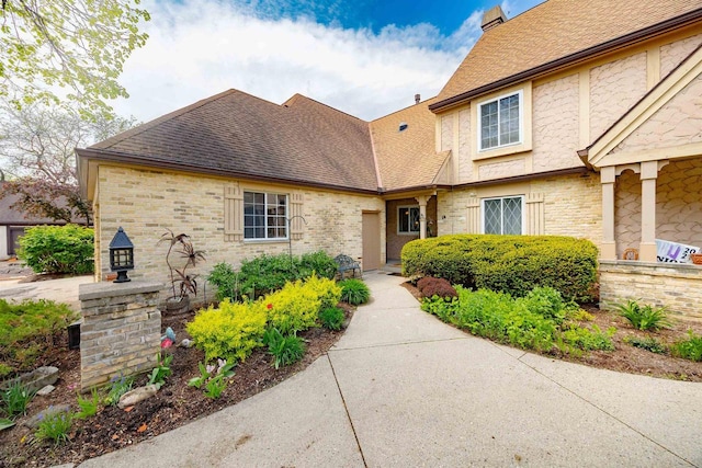 14 Golf Course Rd, Madison, WI 53704 - view of front facade with a shingled roof, a chimney, and stone siding
