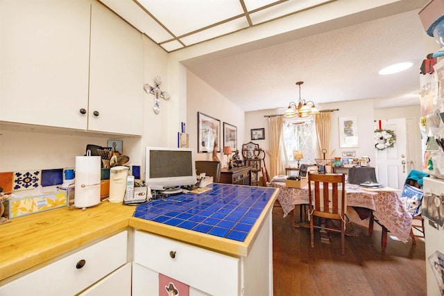 14 Golf Course Rd, Madison, WI 53704 - kitchen with a chandelier, dark wood finished floors, white cabinets, tile countertops, and a peninsula