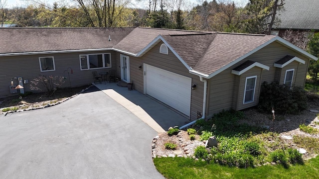 N1423 Silver Canoe Rd, Keshena, WI 54135 - ranch-style house featuring a garage, roof with shingles, and driveway