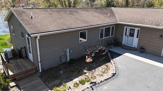 N1423 Silver Canoe Rd, Keshena, WI 54135 - rear view of property featuring a shingled roof, a patio, and central air condition unit
