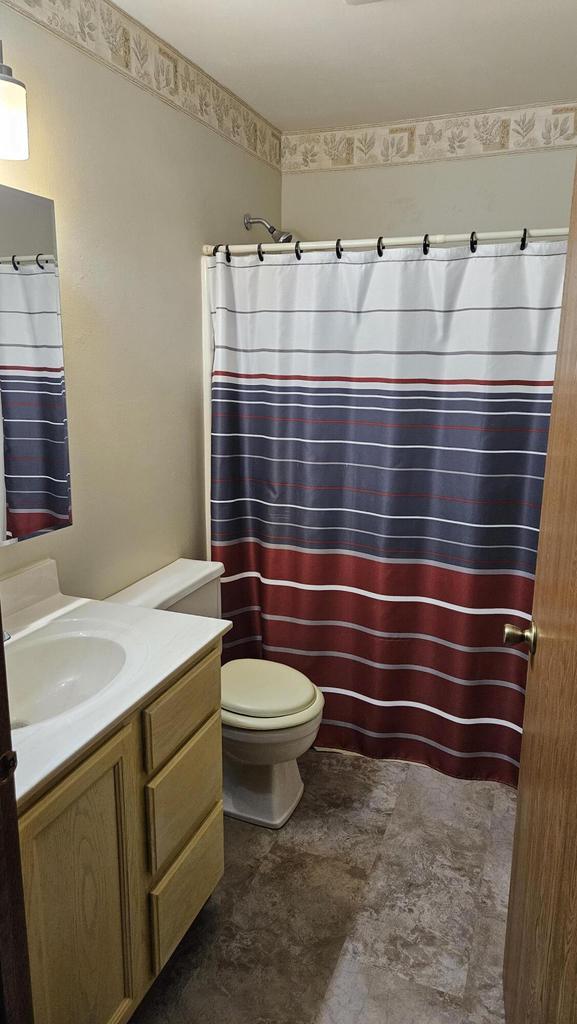7040 Mariner Dr Unit 103, Mount Pleasant, WI 53406 - bathroom featuring vanity, toilet, and a shower with shower curtain