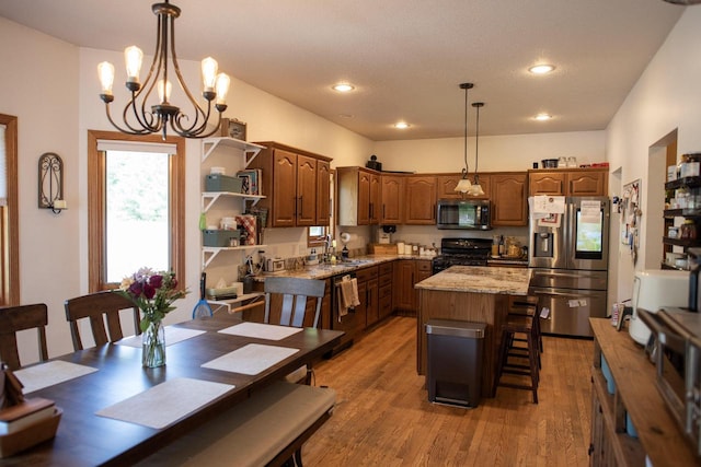 23718 Emblem Ave, Tomah, WI 54660 - kitchen with appliances with stainless steel finishes, a sink, light wood-style floors, a kitchen island, and a chandelier