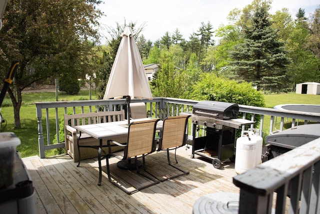 23718 Emblem Ave, Tomah, WI 54660 - wooden terrace with outdoor dining space, a lawn, a shed, and an outdoor structure