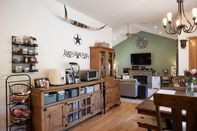23718 Emblem Ave, Tomah, WI 54660 - dining room with ceiling fan, light wood-style floors, a fireplace, a chandelier, and high vaulted ceiling