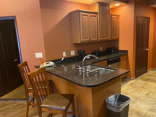 2411 River Rd Unit 2443, Wisconsin Dells, WI 53965 - kitchen featuring a sink, a textured wall, a peninsula, dishwasher, and a kitchen bar
