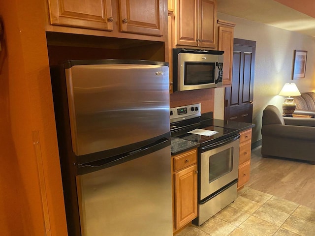 2411 River Rd Unit 2443, Wisconsin Dells, WI 53965 - kitchen with stainless steel appliances, open floor plan, dark stone countertops, and brown cabinetry