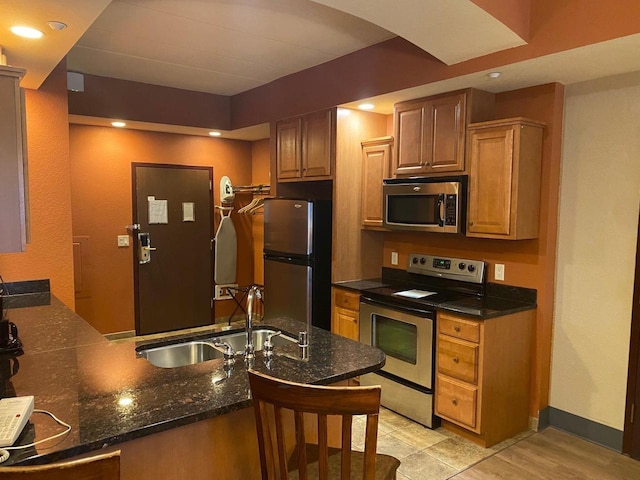2411 River Rd Unit 2443, Wisconsin Dells, WI 53965 - kitchen with stainless steel appliances, a sink, a peninsula, dark stone counters, and baseboards