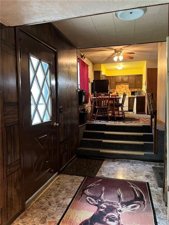 W4670 County Highway F, Springbrook, WI 54875 - foyer entrance featuring ceiling fan, wood walls, and stairway