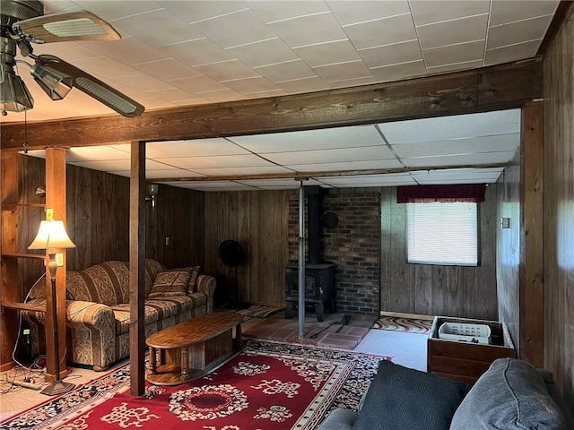 W4670 County Highway F, Springbrook, WI 54875 - living room with wooden walls, a wood stove, and a paneled ceiling