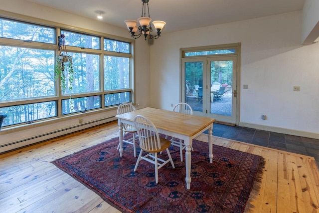 8395 Woolpy Dr, Minocqua, WI 54548 - dining area with a baseboard heating unit, hardwood / wood-style flooring, a chandelier, and baseboards