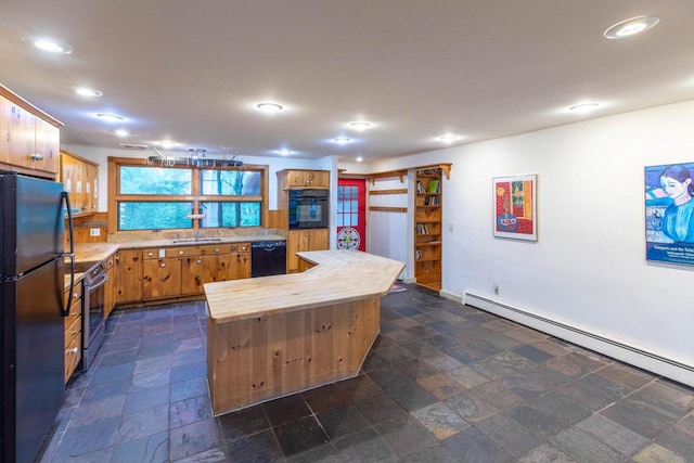 8395 Woolpy Dr, Minocqua, WI 54548 - kitchen featuring a baseboard heating unit, black appliances, wooden counters, stone tile flooring, and a kitchen island