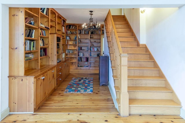 8395 Woolpy Dr, Minocqua, WI 54548 - staircase featuring a chandelier and wood finished floors