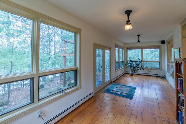 8395 Woolpy Dr, Minocqua, WI 54548 - unfurnished sunroom featuring healthy amount of natural light, hardwood / wood-style floors, and a baseboard radiator