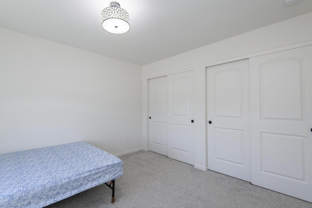 W242N5663 Simona Dr, Sussex, WI 53089 - bedroom featuring light colored carpet, two closets, and baseboards