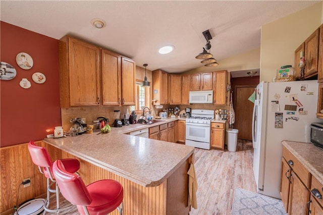 18886 53rd Ave, Chippewa Falls, WI 54729 - kitchen featuring white appliances, a sink, a peninsula, light countertops, and lofted ceiling