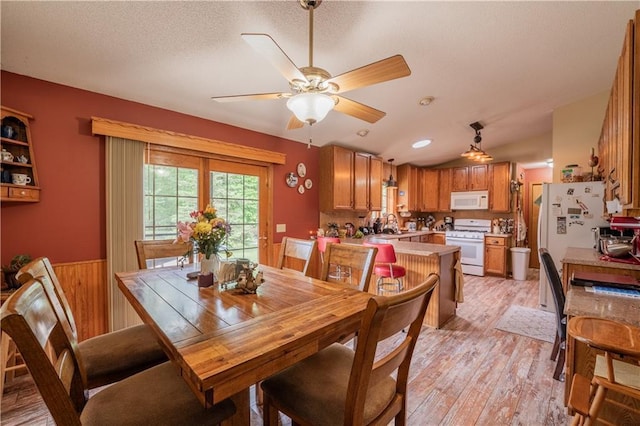 18886 53rd Ave, Chippewa Falls, WI 54729 - dining space with a wainscoted wall, light wood finished floors, ceiling fan, wood walls, and a textured ceiling