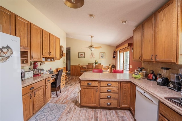 18886 53rd Ave, Chippewa Falls, WI 54729 - kitchen featuring white appliances, a peninsula, vaulted ceiling, light countertops, and brown cabinetry