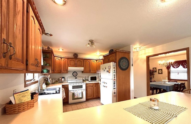 12541 Fleetwood Rd, Tomah, WI 54660 - kitchen with white appliances, a sink, a chandelier, under cabinet range hood, and light countertops