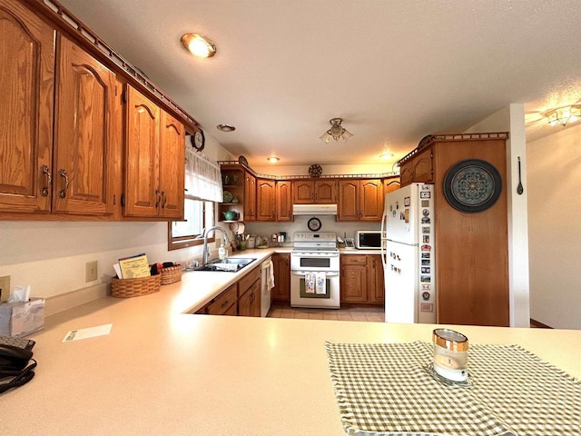 12541 Fleetwood Rd, Tomah, WI 54660 - kitchen with white appliances, a sink, under cabinet range hood, light countertops, and brown cabinets