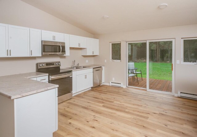 N3725 County Road Ee, Redgranite, WI 54970 - kitchen featuring appliances with stainless steel finishes, a baseboard radiator, light wood-style floors, white cabinetry, and vaulted ceiling