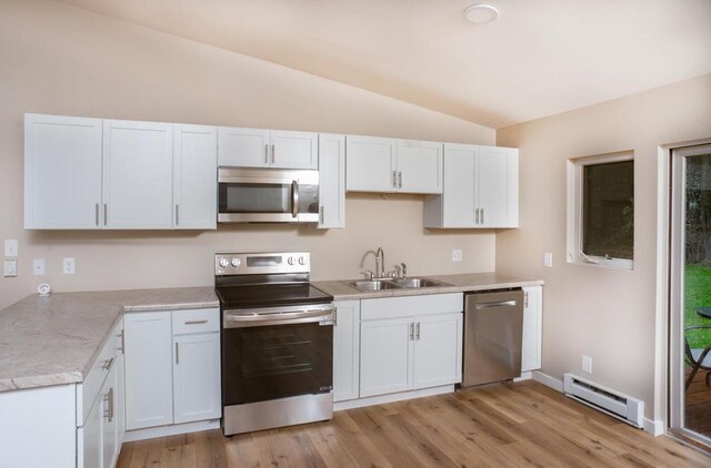 N3725 County Road Ee, Redgranite, WI 54970 - kitchen with stainless steel appliances, a baseboard radiator, a sink, vaulted ceiling, and light countertops