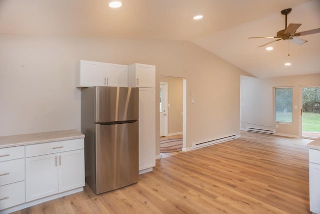 N3725 County Road Ee, Redgranite, WI 54970 - kitchen featuring freestanding refrigerator, baseboard heating, vaulted ceiling, light wood-style floors, and white cabinets