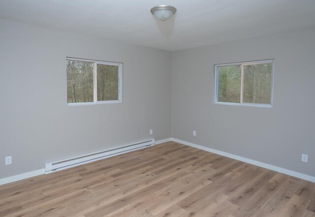 N3725 County Road Ee, Redgranite, WI 54970 - empty room featuring a baseboard heating unit, healthy amount of natural light, wood finished floors, and baseboards