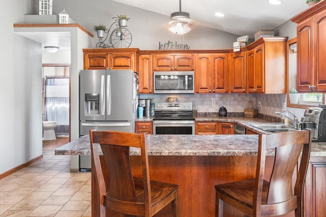 2891 Yellow Jasmine Way, Green Bay, WI 54313 - kitchen with stainless steel appliances, decorative backsplash, a sink, vaulted ceiling, and a kitchen bar
