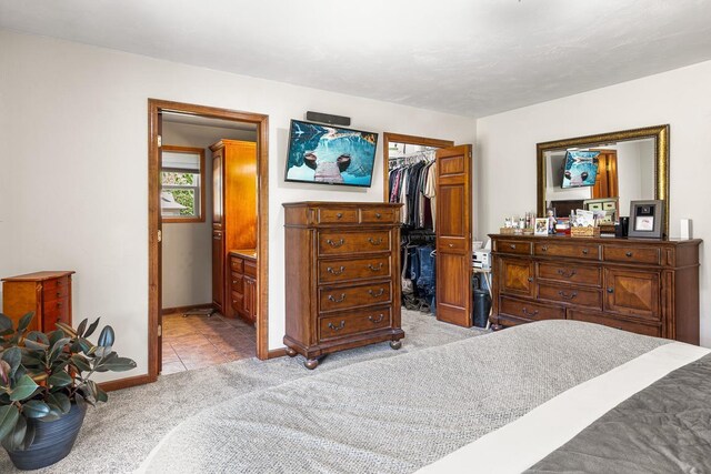 2891 Yellow Jasmine Way, Green Bay, WI 54313 - bedroom with light carpet, a walk in closet, a closet, baseboards, and ensuite bathroom