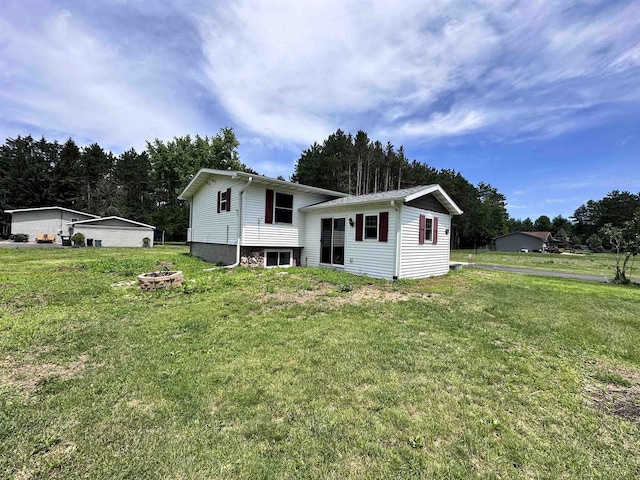 6111 Magnolia Dr, Wisconsin Rapids, WI 54494 - rear view of property with a yard and a fire pit
