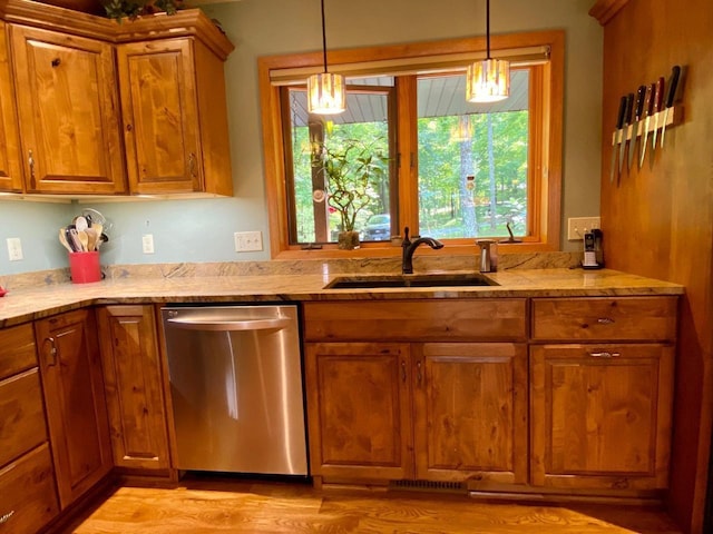 7002 Wildwood Ln, Rhinelander, WI 54501 - kitchen featuring dishwasher, brown cabinets, a sink, and light stone counters