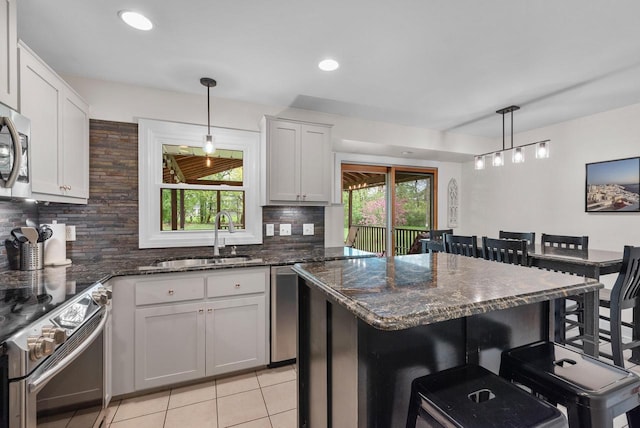 N51W15940 Fair Oak Pkwy, Menomonee Falls, WI 53051 - kitchen featuring stainless steel appliances, a sink, backsplash, a breakfast bar area, and recessed lighting