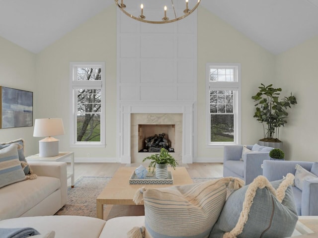 5021 Sherwood Ct, Burlington, WI 53105 - living room featuring high vaulted ceiling, a chandelier, light wood-style floors, a high end fireplace, and baseboards