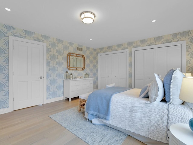 5021 Sherwood Ct, Burlington, WI 53105 - bedroom with wallpapered walls, multiple closets, light wood finished floors, baseboards, and recessed lighting