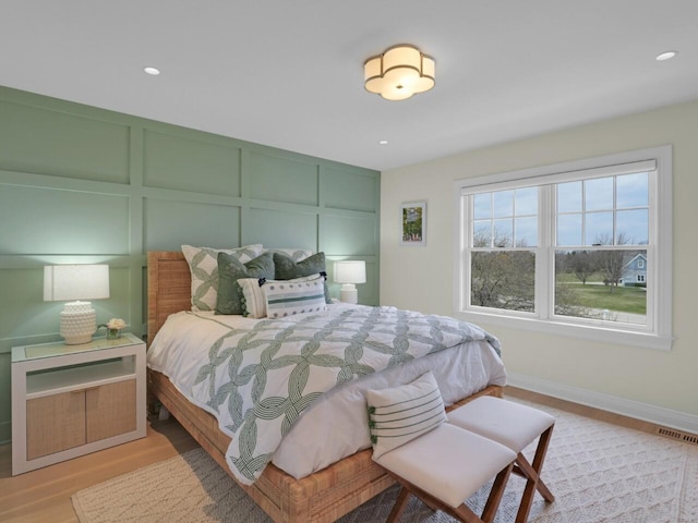 5021 Sherwood Ct, Burlington, WI 53105 - bedroom with a decorative wall, wood finished floors, recessed lighting, and baseboards