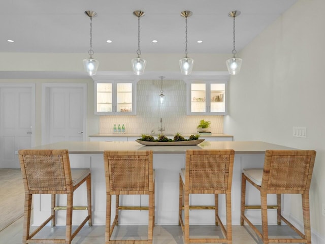 5021 Sherwood Ct, Burlington, WI 53105 - kitchen featuring backsplash, light countertops, glass insert cabinets, decorative light fixtures, and recessed lighting