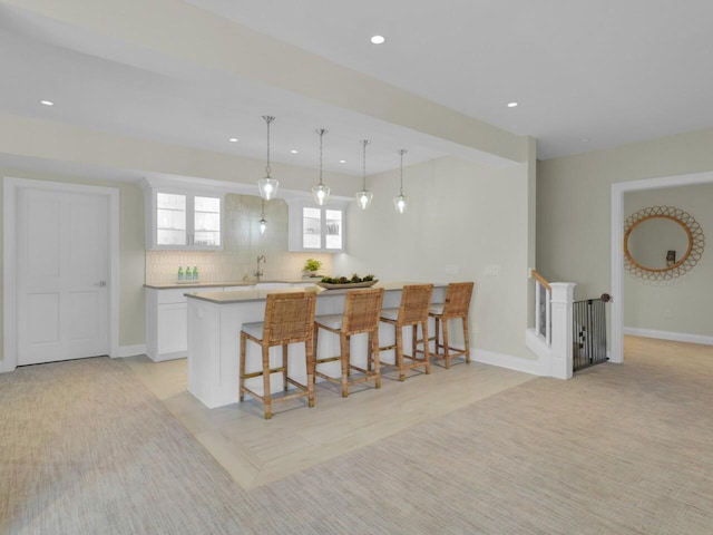 5021 Sherwood Ct, Burlington, WI 53105 - kitchen featuring a kitchen breakfast bar, white cabinets, decorative backsplash, recessed lighting, and light countertops