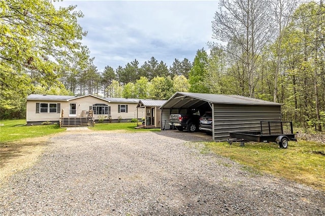 W14312 Montgomery Rd, Hixton, WI 54635 - manufactured / mobile home with a detached carport, driveway, and a wooden deck