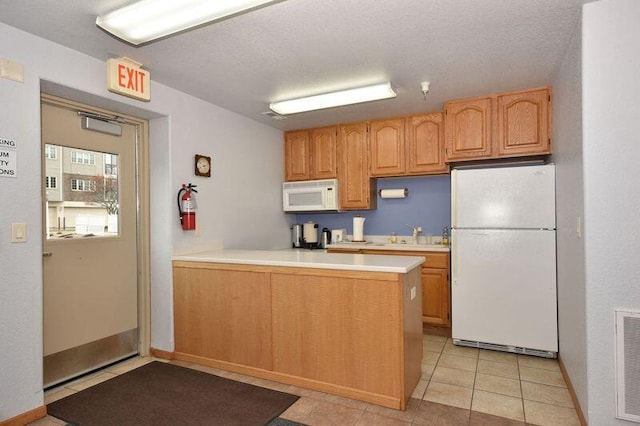 2142 Chateau Ct Unit 308-2, Grafton, WI 53024 - kitchen with white appliances, light countertops, a peninsula, light tile patterned floors, and a sink