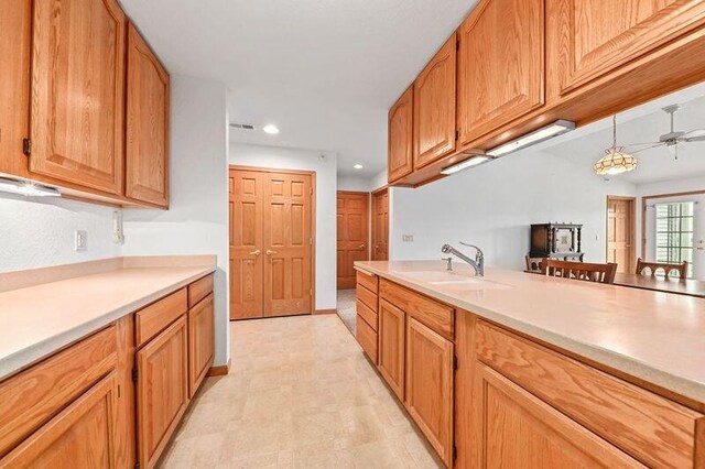 2142 Chateau Ct Unit 308-2, Grafton, WI 53024 - kitchen featuring a sink, light countertops, recessed lighting, ceiling fan, and brown cabinets
